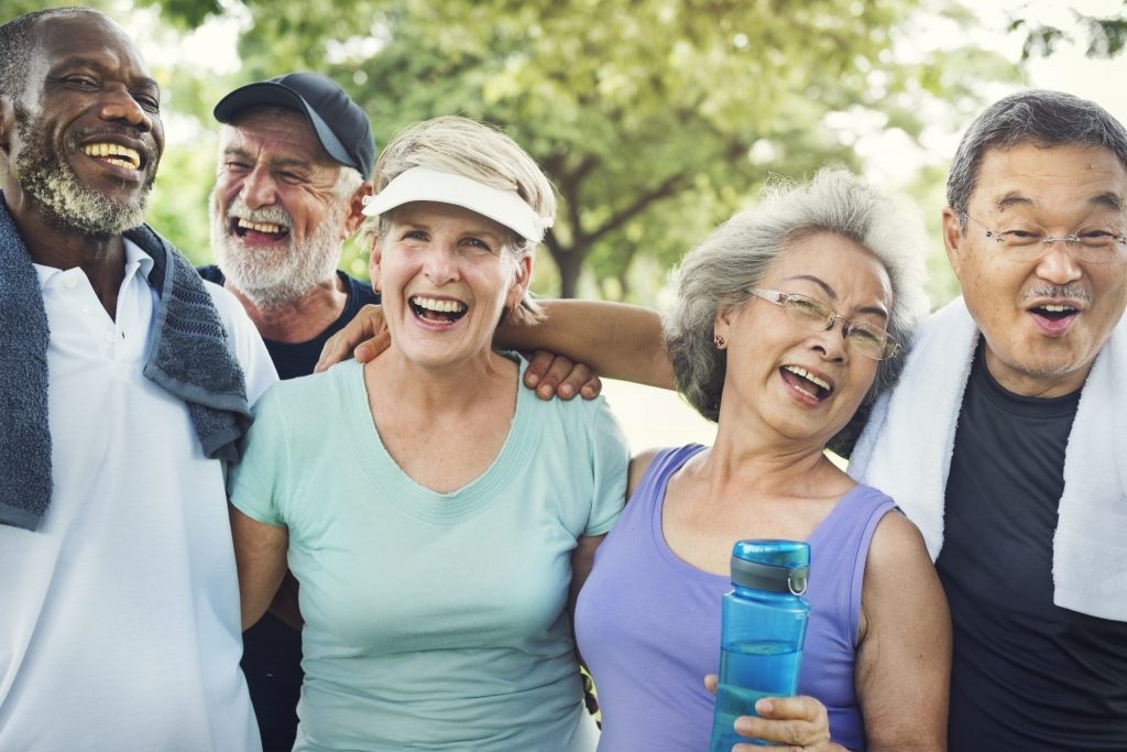 Bild einer lachenden Gruppe an Senioren mit verschiedenen Herkünften. Beispielbild für die Riester Rente.